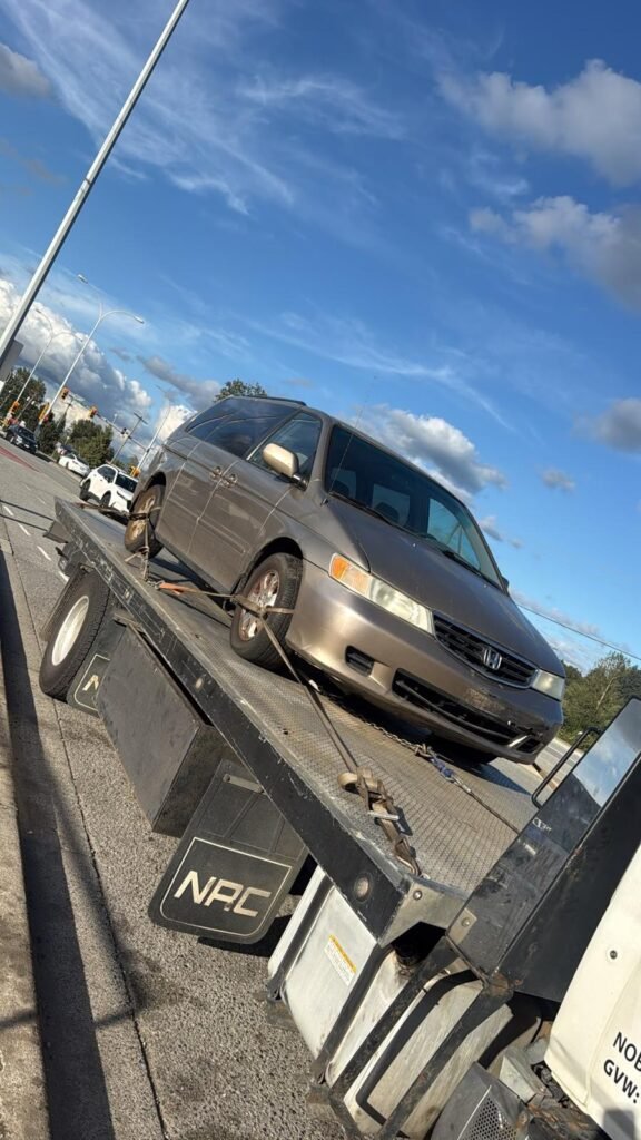 Grey minivan secured on a flatbed